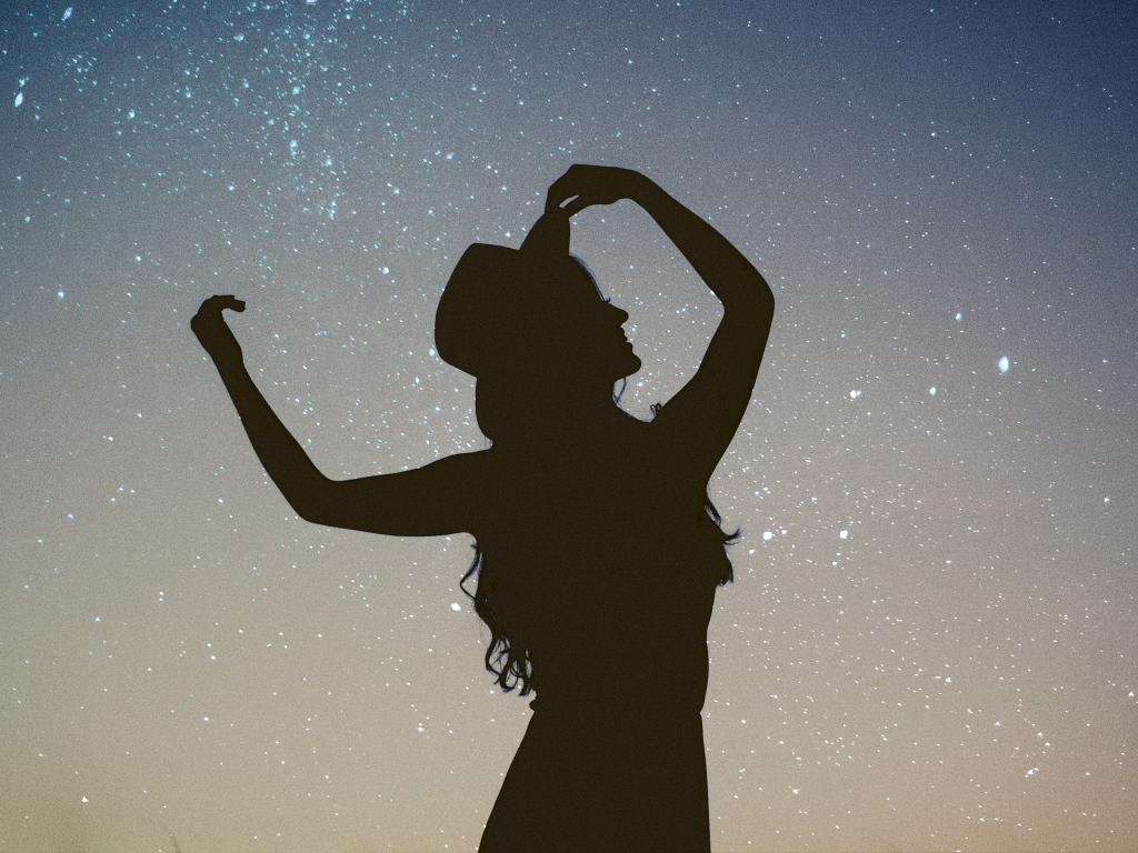 Силуэт девушки в шляпе на фоне неба