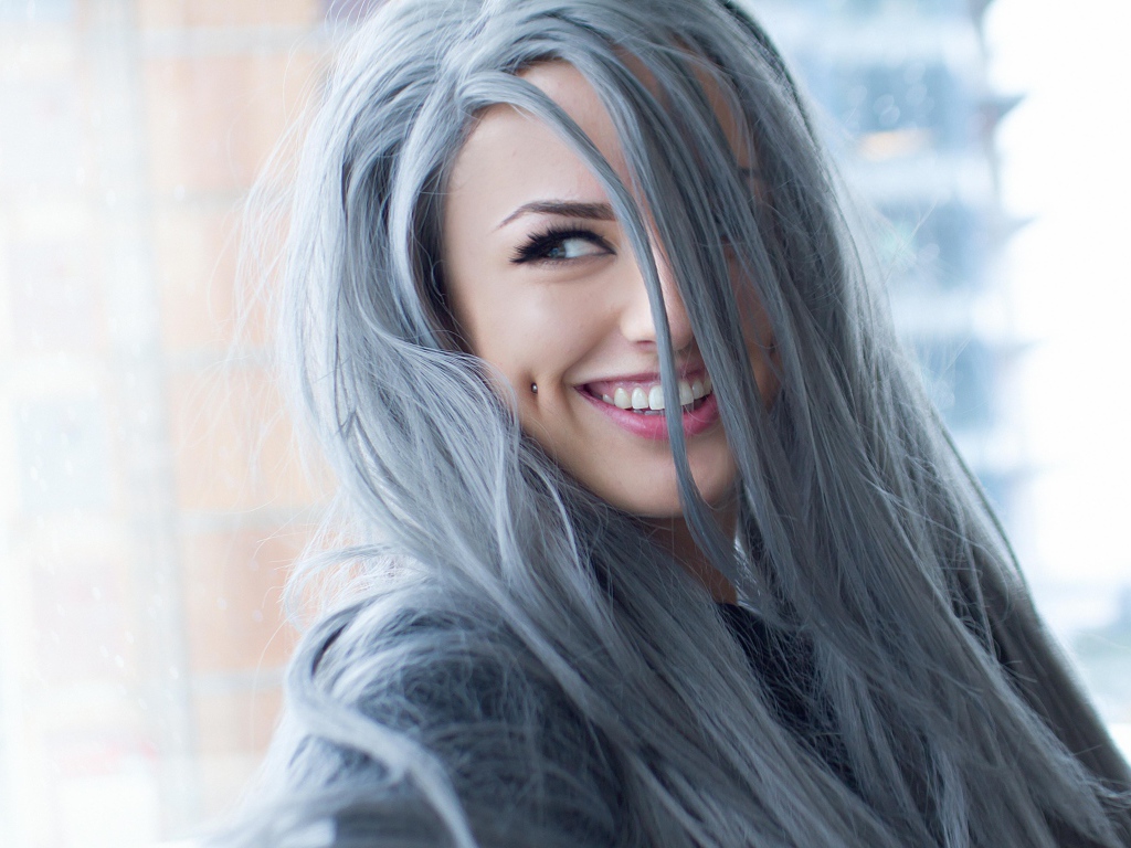 Улыбающаяся эпатажная девушка с пирсингом