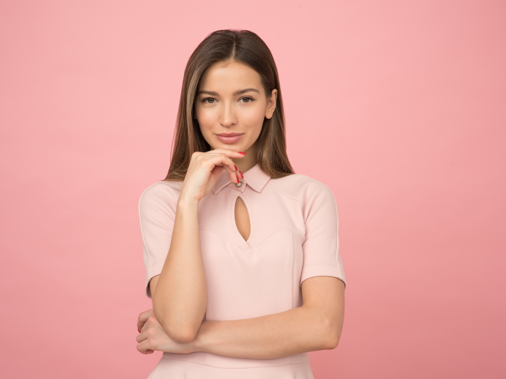 Стильная молодая девушка на розовом фоне 