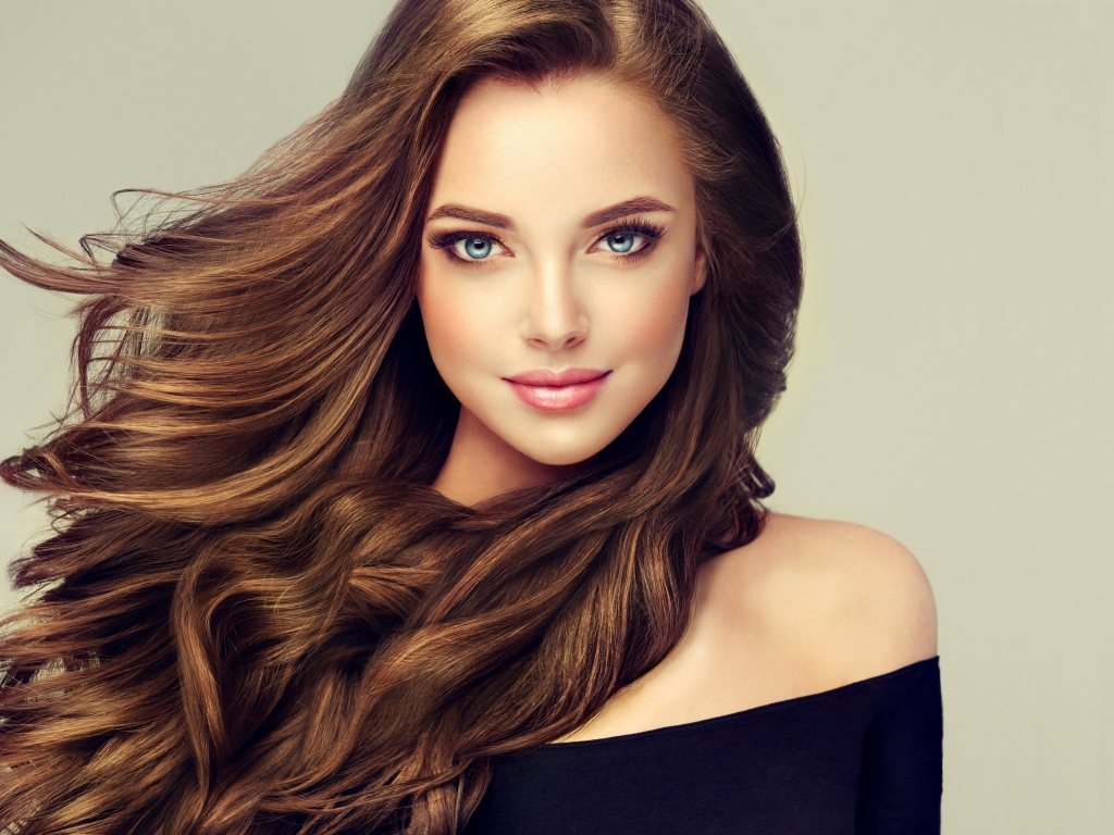 Молодая голубоглазая девушка с красивыми длинными волосами