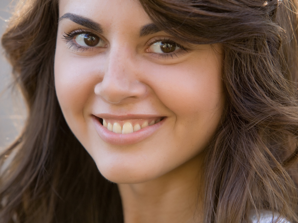 Молодая кареглазая брюнетка с очаровательной улыбкой