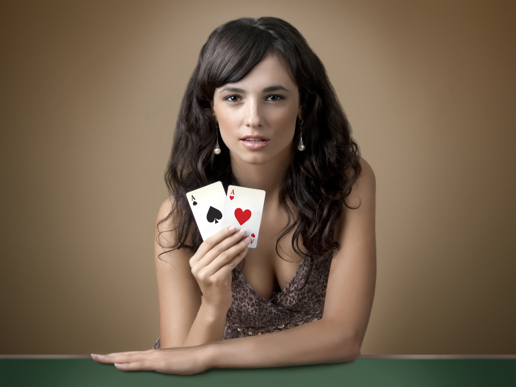 Молодая брюнетка с двумя карточными тузами в руке