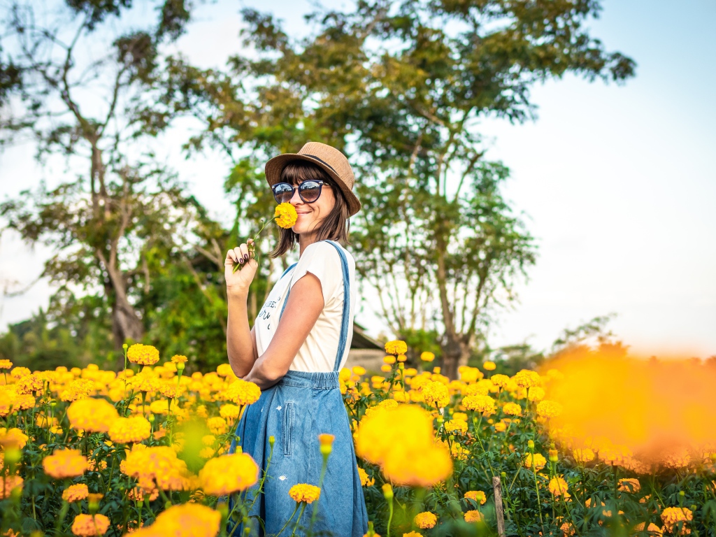 Молодая девушка в солнечных очках в желтых цветах 