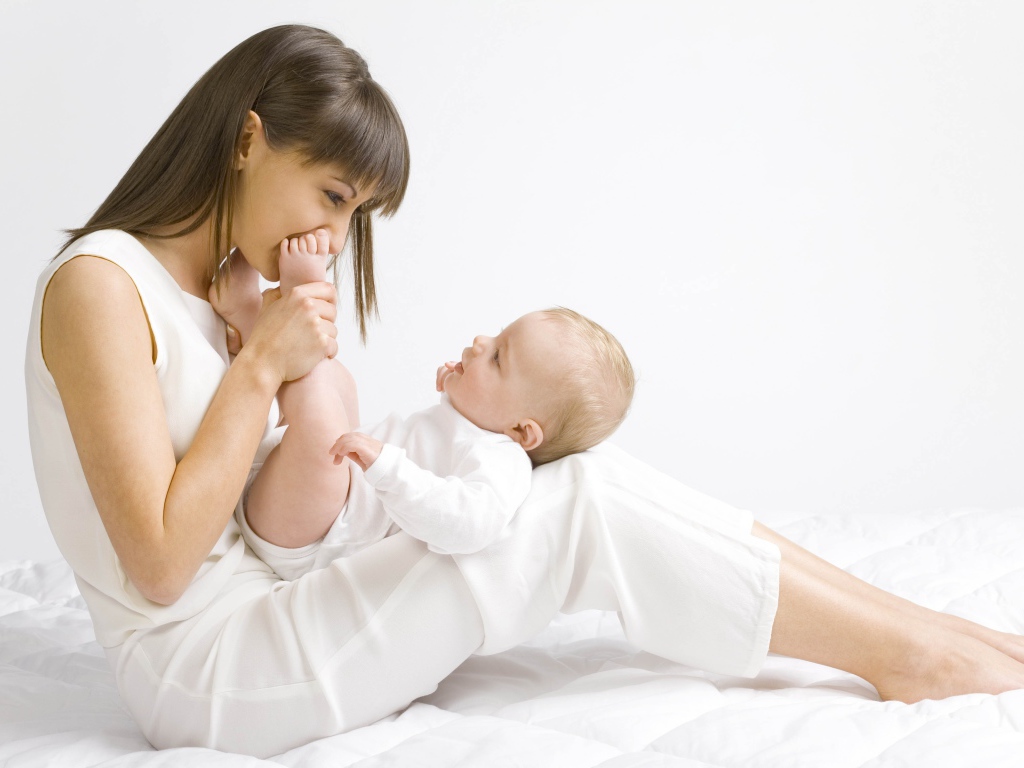 Молодая девушка в белом с младенцем