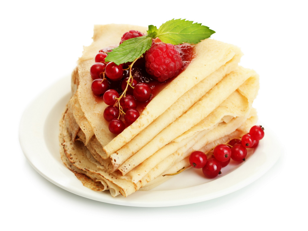 Тонкие блины с малиной и красной смородиной на белом фоне на Масленицу
