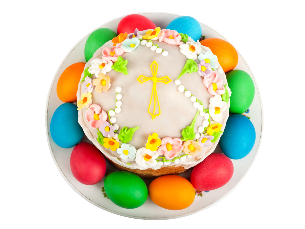 Красивый пасхальный кулич с цветами и разноцветными крашеными яйцами на белом фоне