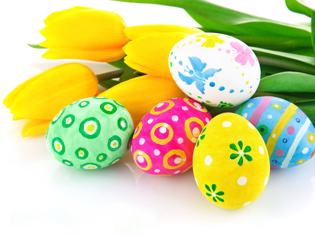 Разукрашенные яйца с букетом желтых тюльпанов на белом фоне на Пасху