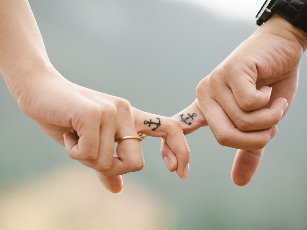 Руки влюбленной пары с татуировками на руках 