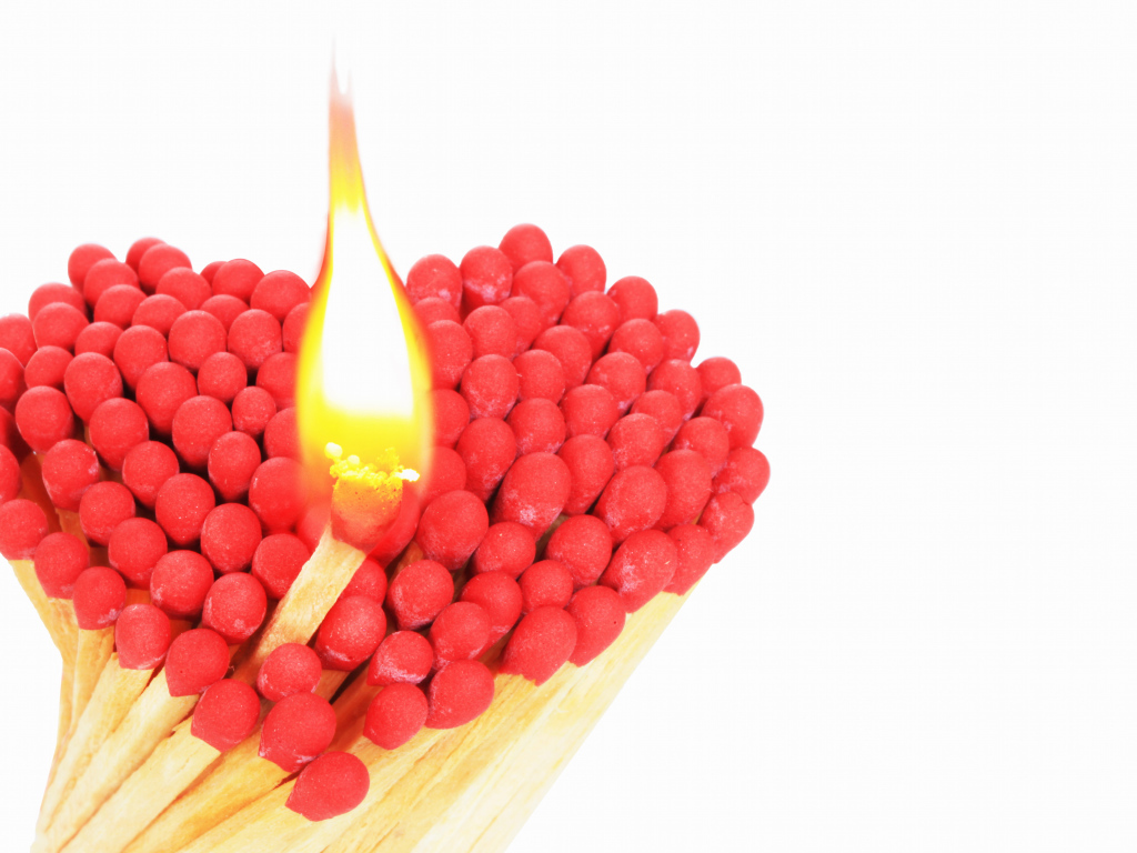 Сердце из спичек с красной серой на белом фоне