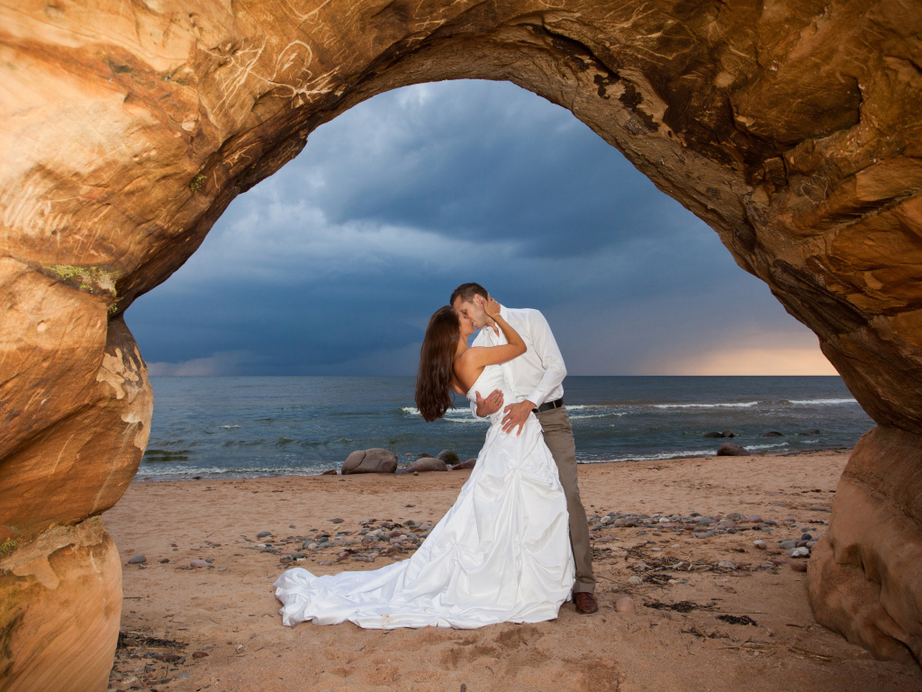 Поцелуй жениха и невесты на фоне моря