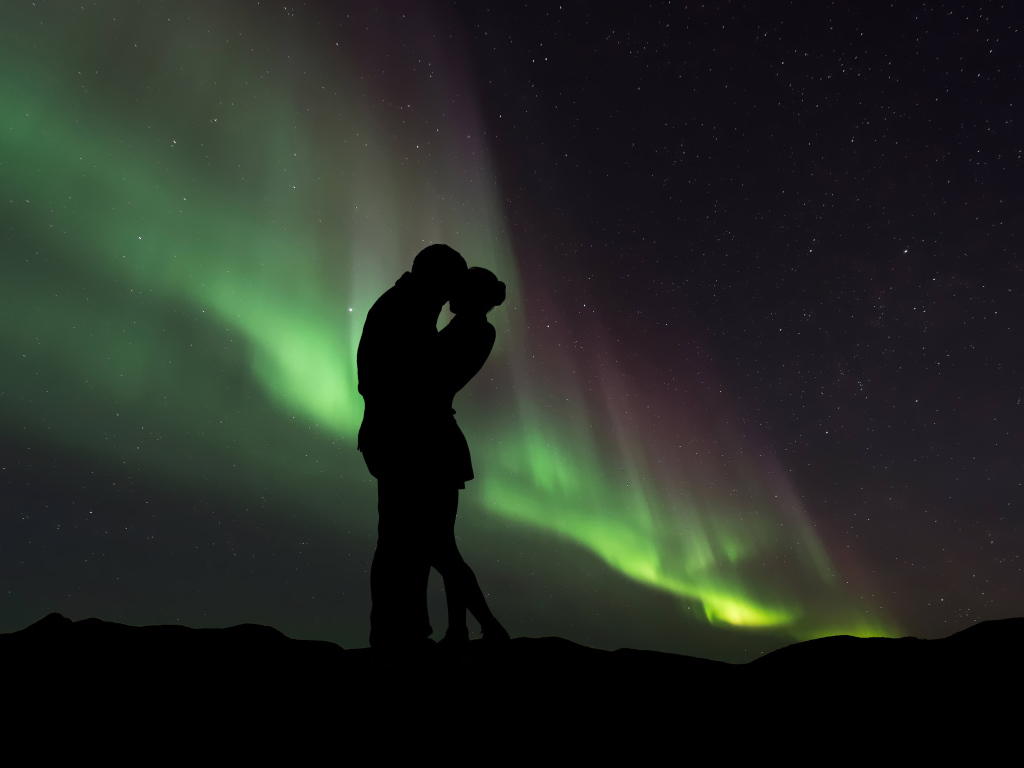 Силуэт влюбленной пары на фоне северного сияния 
