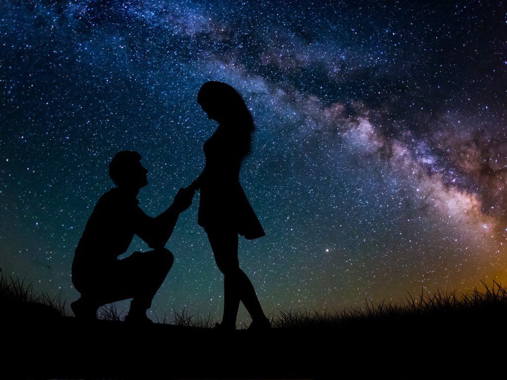 Силуэты влюбленной пары на фоне звездного неба ночью 