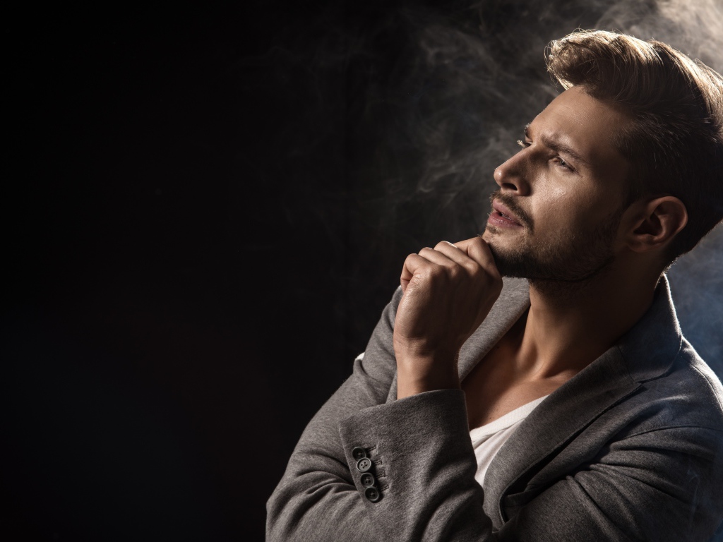 Красивый задумчивый мужчина в сером пиджаке