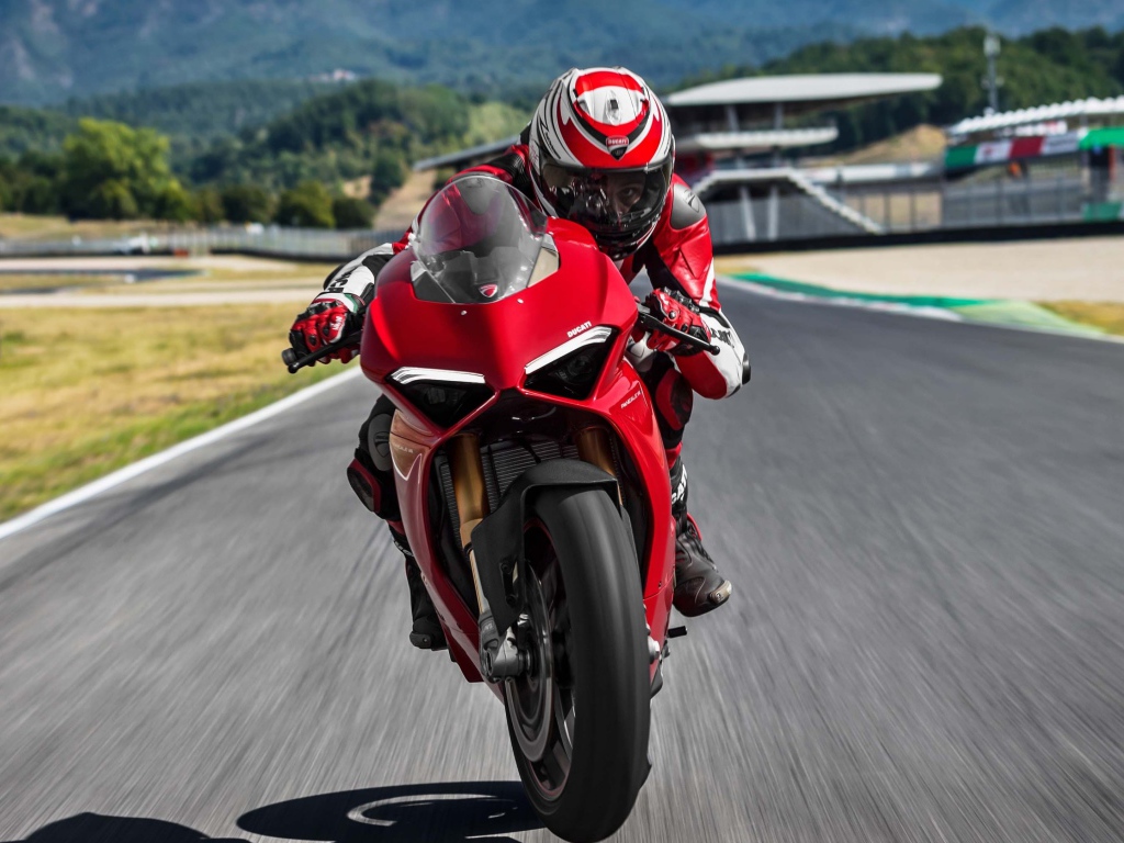 Красный мотоцикл  Ducati Panigale V4 S, 2018 на трассе с мотогонщиком