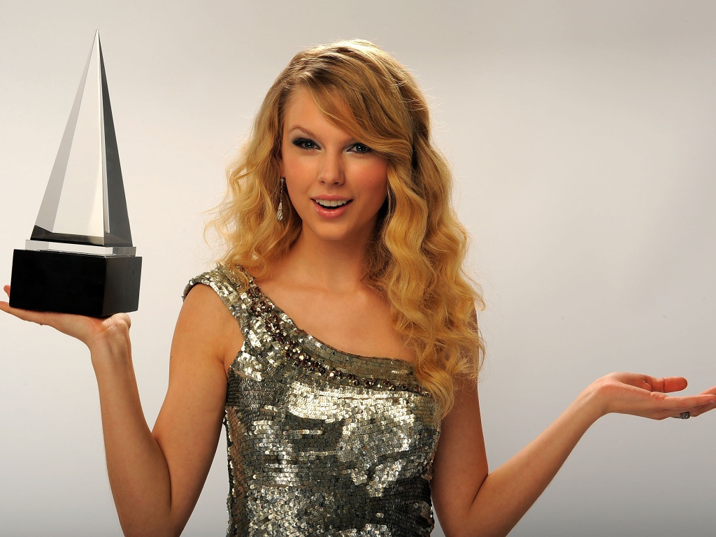 Красивая блондинка певица Тейлор Свифт с наградой в руке 