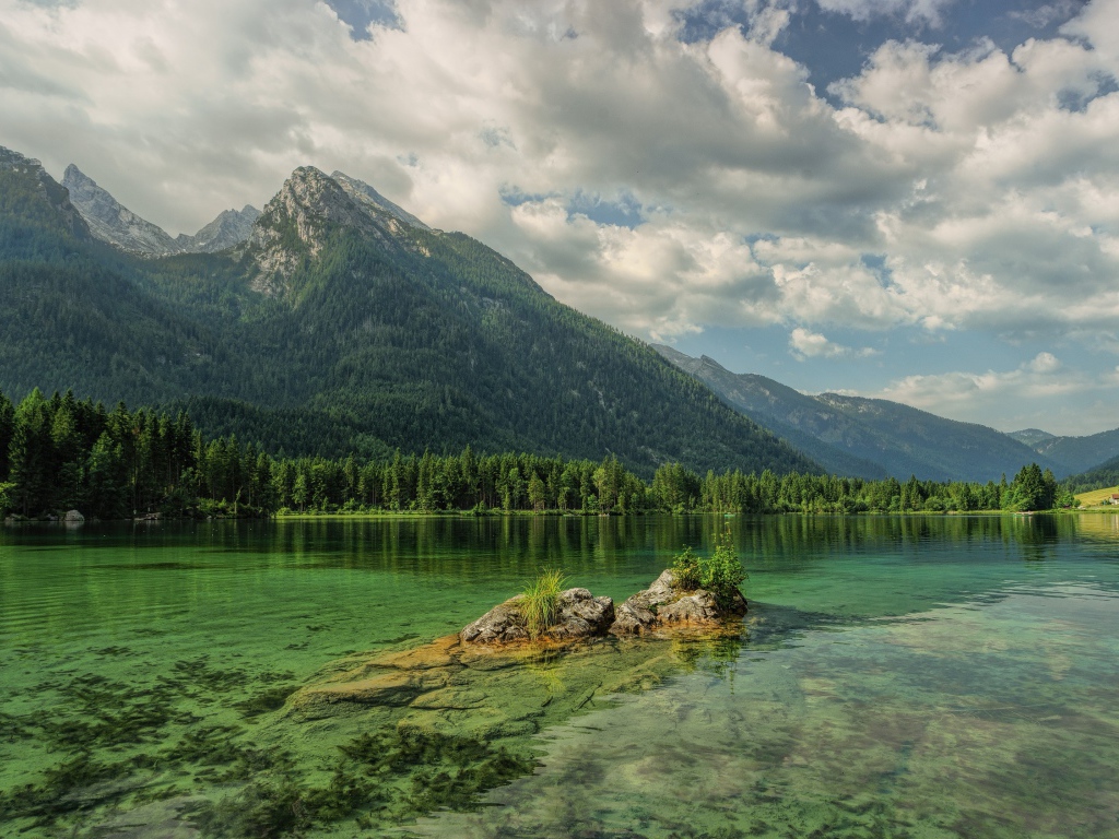 Покрытые хвойным лесом горы отражаются в озере