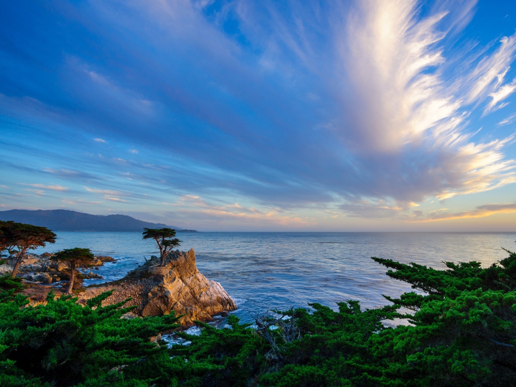 Скалистый морской берег под голубым небом с красивыми белыми облаками