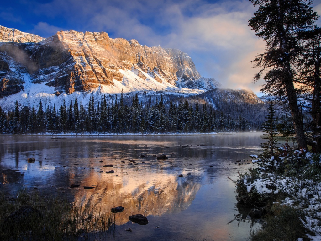Покрытые снегом горы у заледеневшего озера