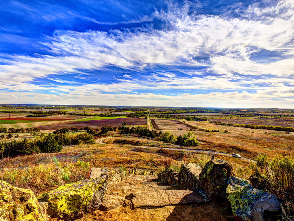 Вид на поле под красивым голубым небом с белыми облаками