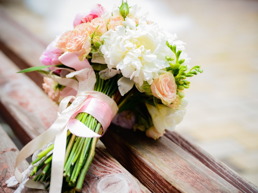Красивый свадебный букет лежит на деревянной лавке