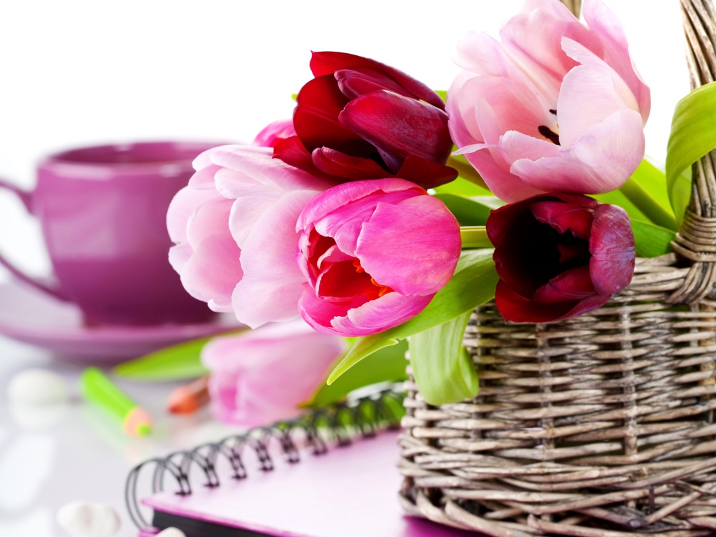 Букет разноцветных тюльпанов в корзине на столе с блокнотом