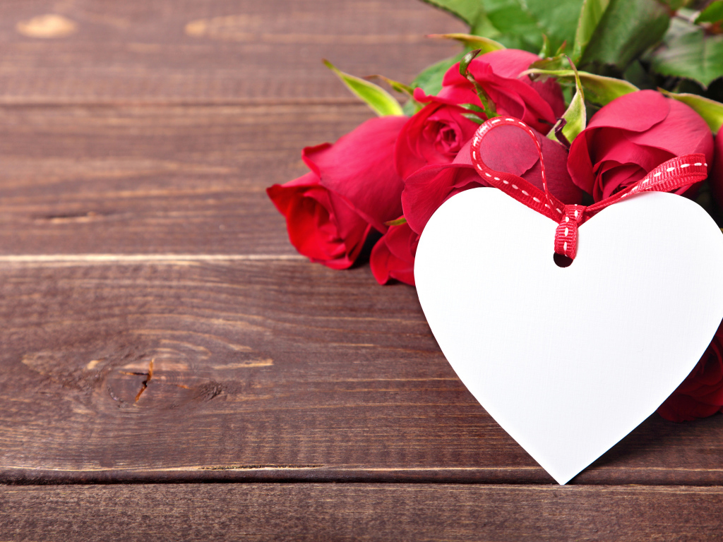 Букет розовых роз с бумажным сердцем на деревянном фоне