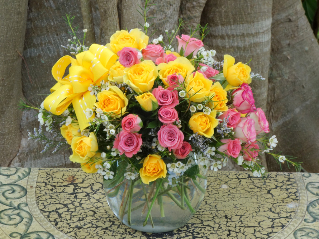 Букет желтых и розовых роз в стеклянной вазе