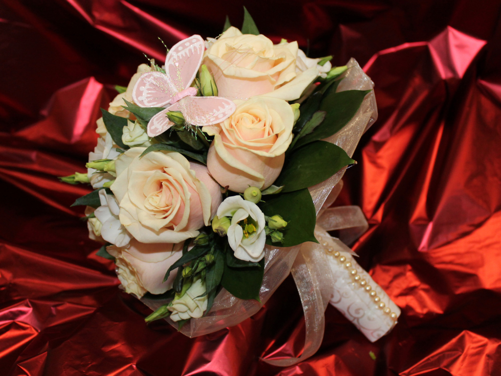 Нежный свадебный букет с цветами розовой розы и эустомы на красном фоне