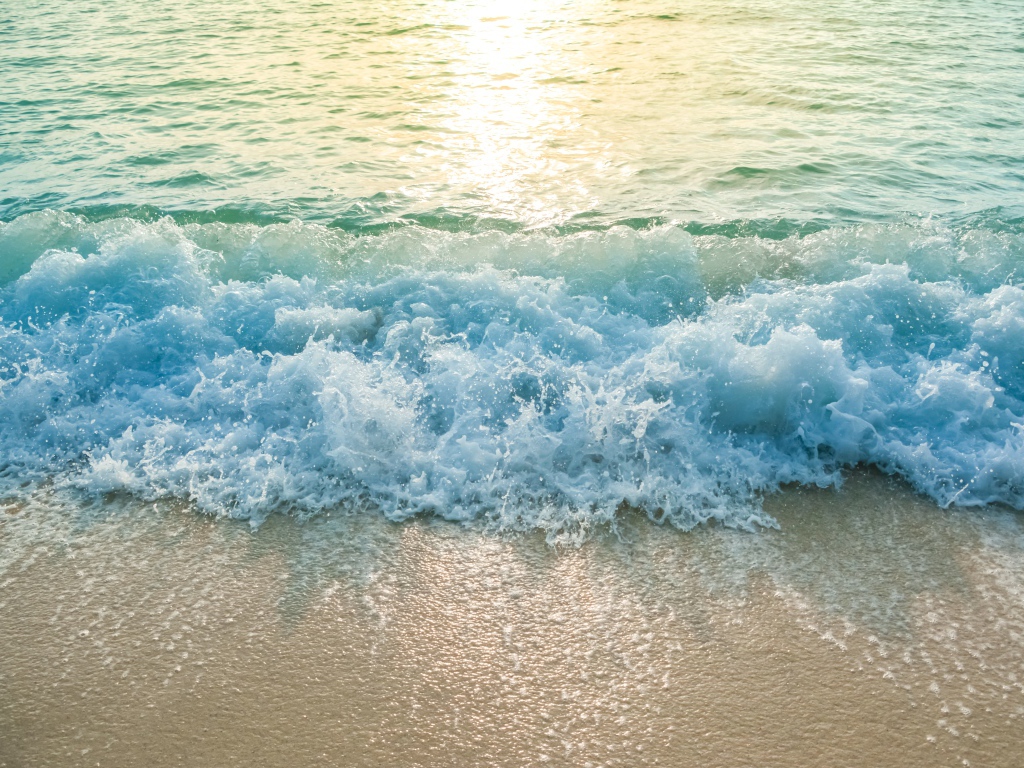 Голубая волна на желтом морском песке