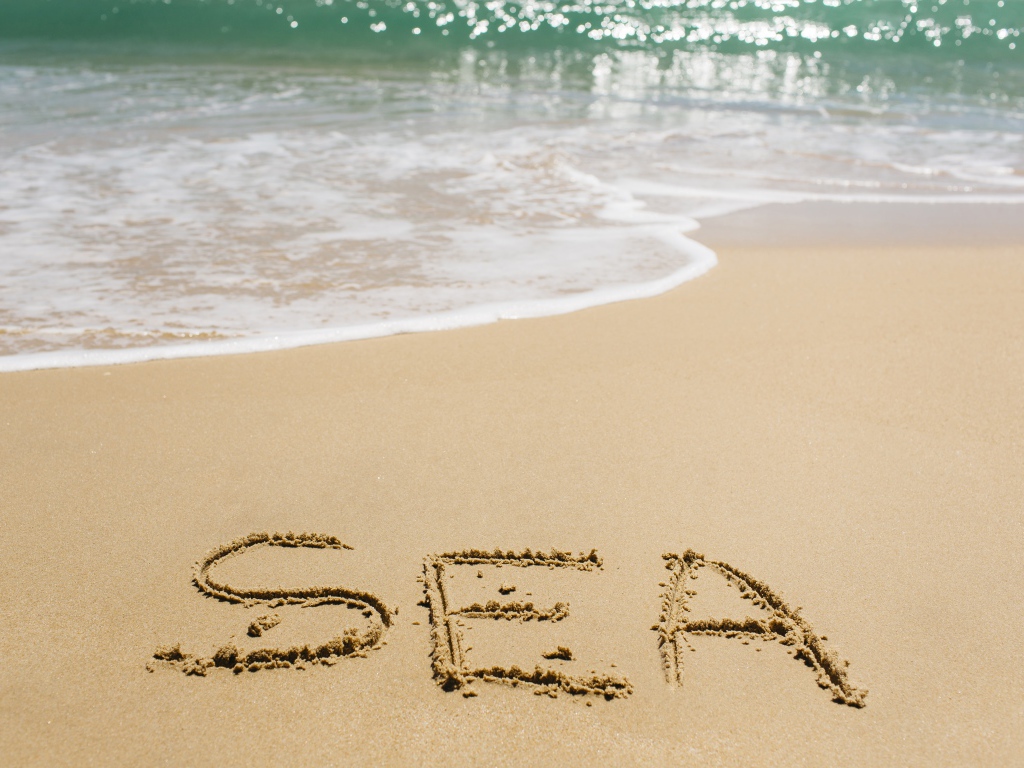 Надпись на песке у моря летом