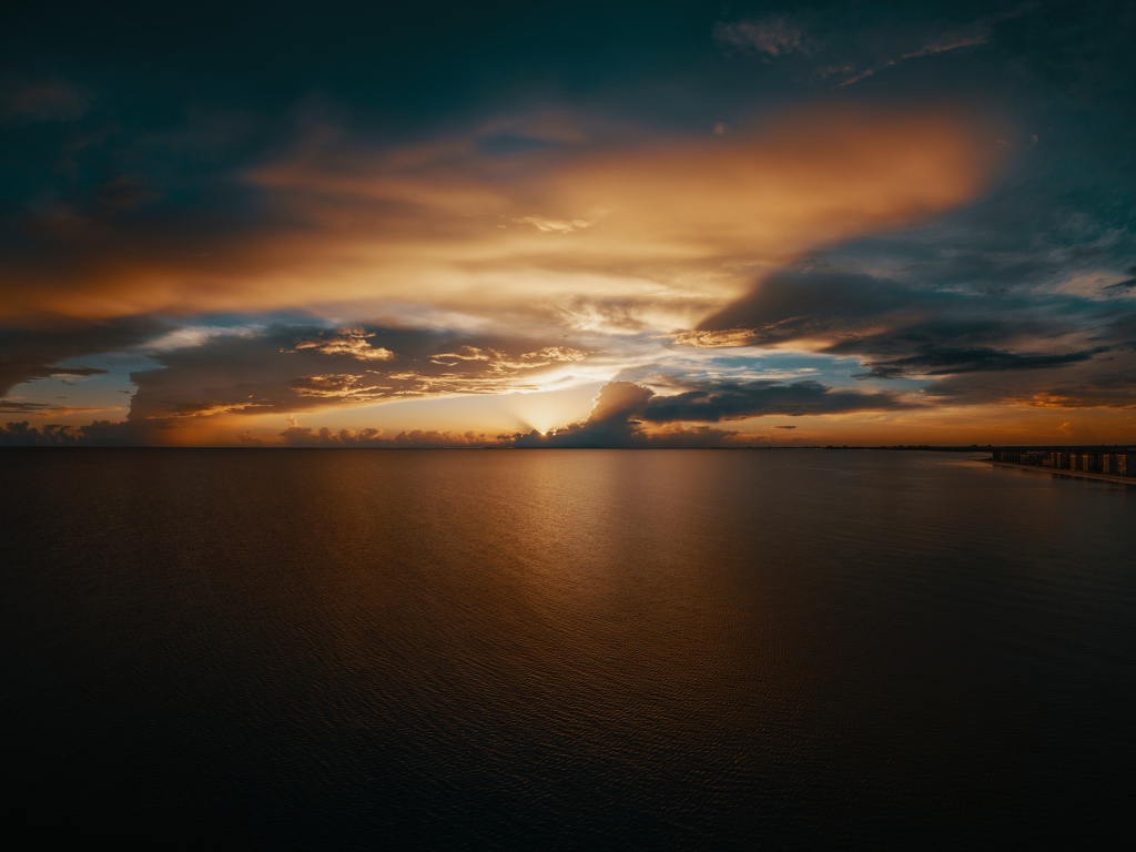 Закат солнца в красивом небе над тихой водой моря