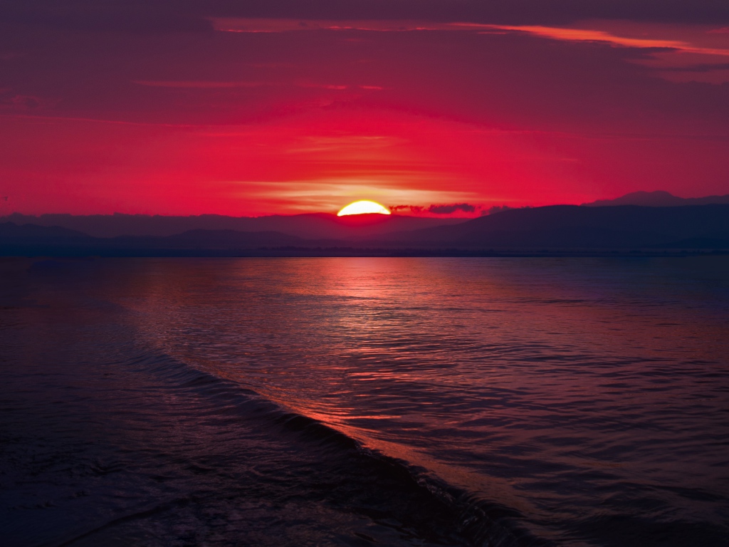 Закат красного солнца на морском горизонте 