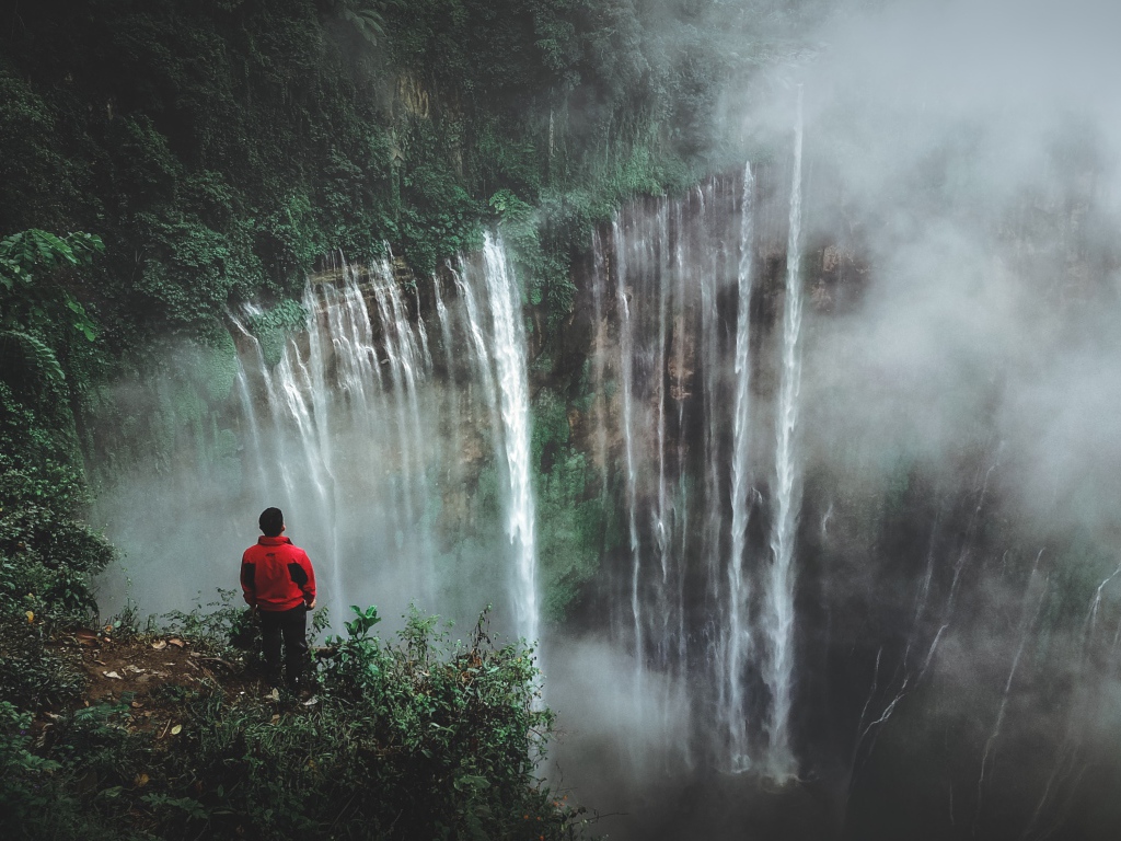 Человек смотрит на водопад сверху. 