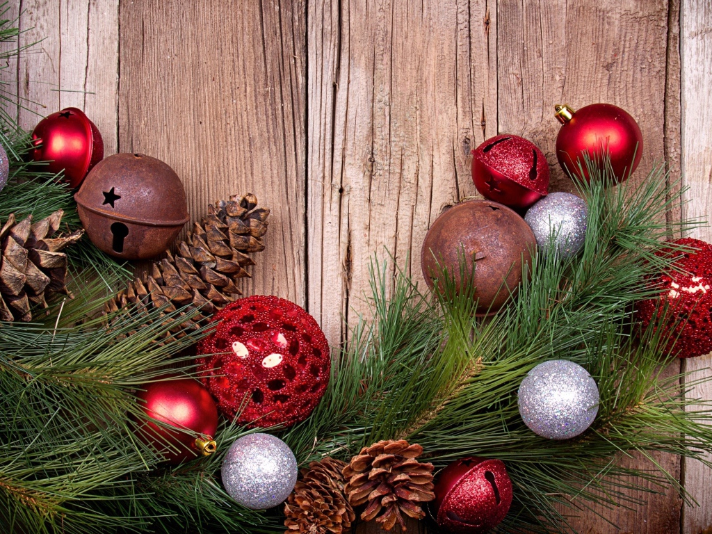 Зеленая еловая ветка с шишками и игрушками на деревянном фоне