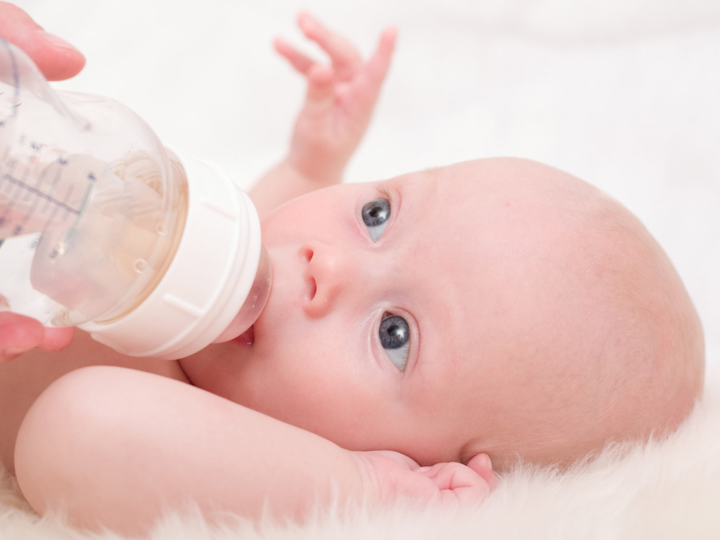 Новорожденного ребенка кормят с бутылки