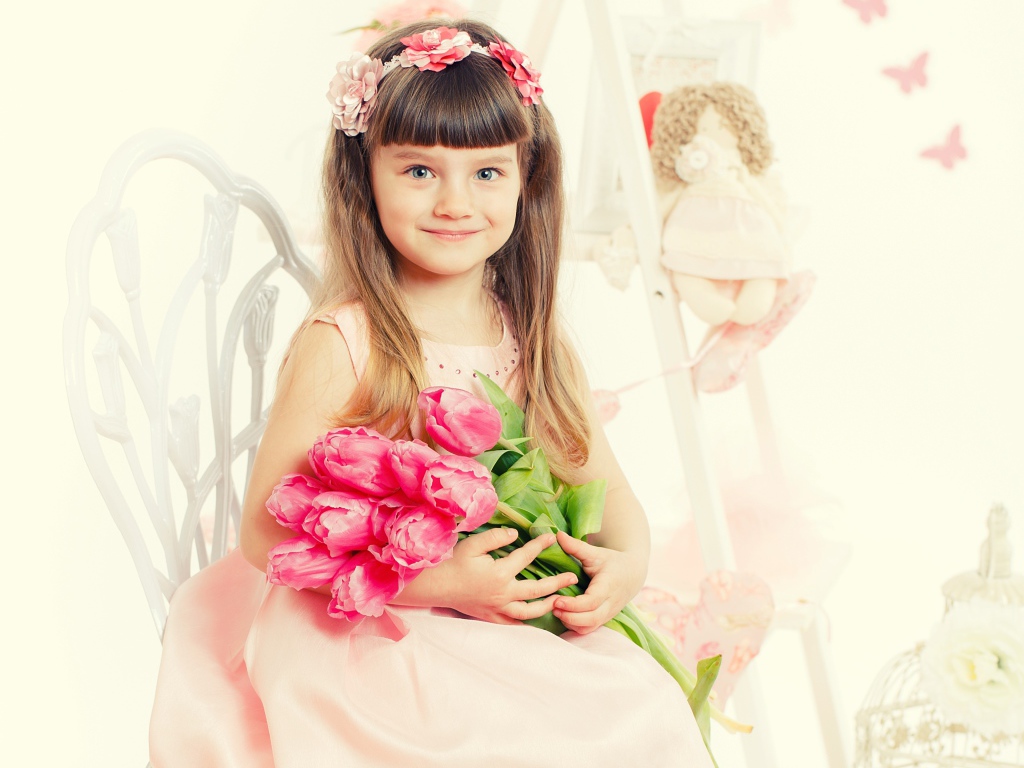 Красивая милая голубоглазая девочка с букетом розовых тюльпанов