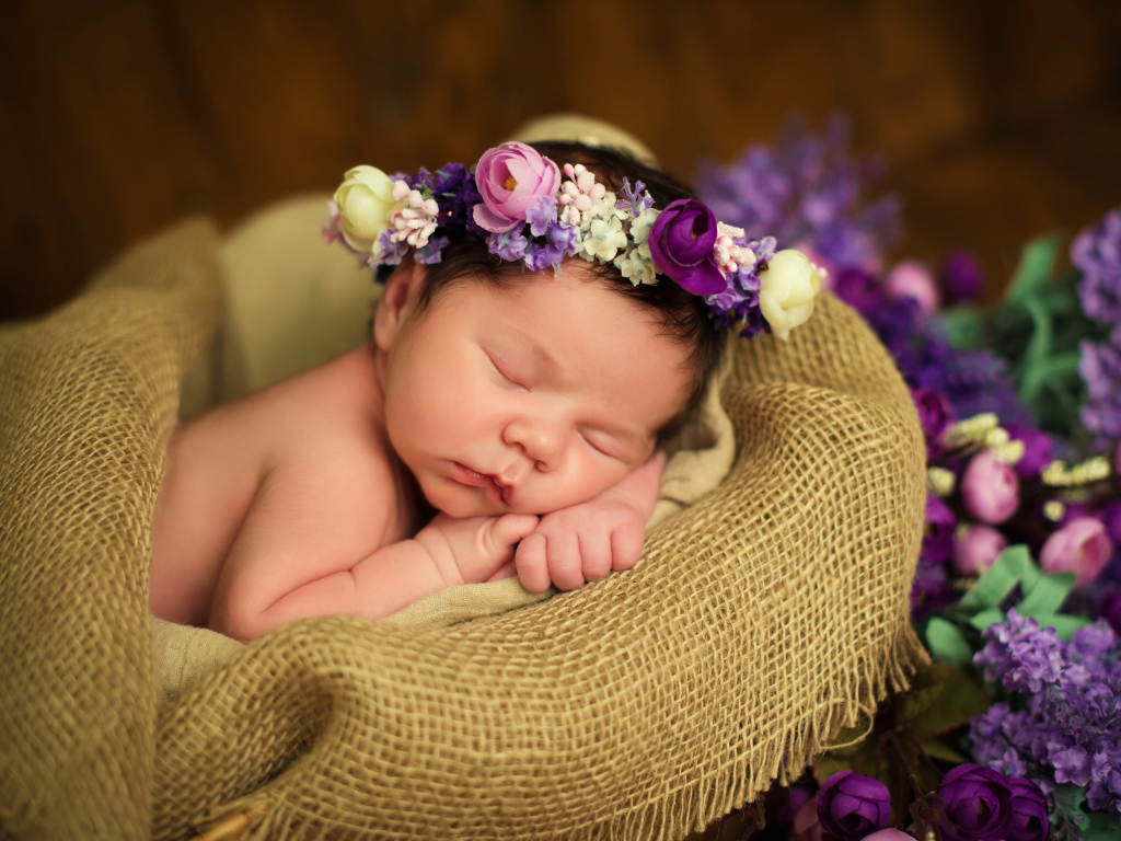 Милый спящий младенец с венком на голове