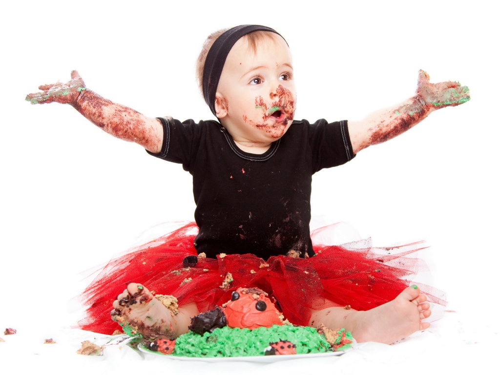 Маленькая смешная девочка в торте на белом фоне