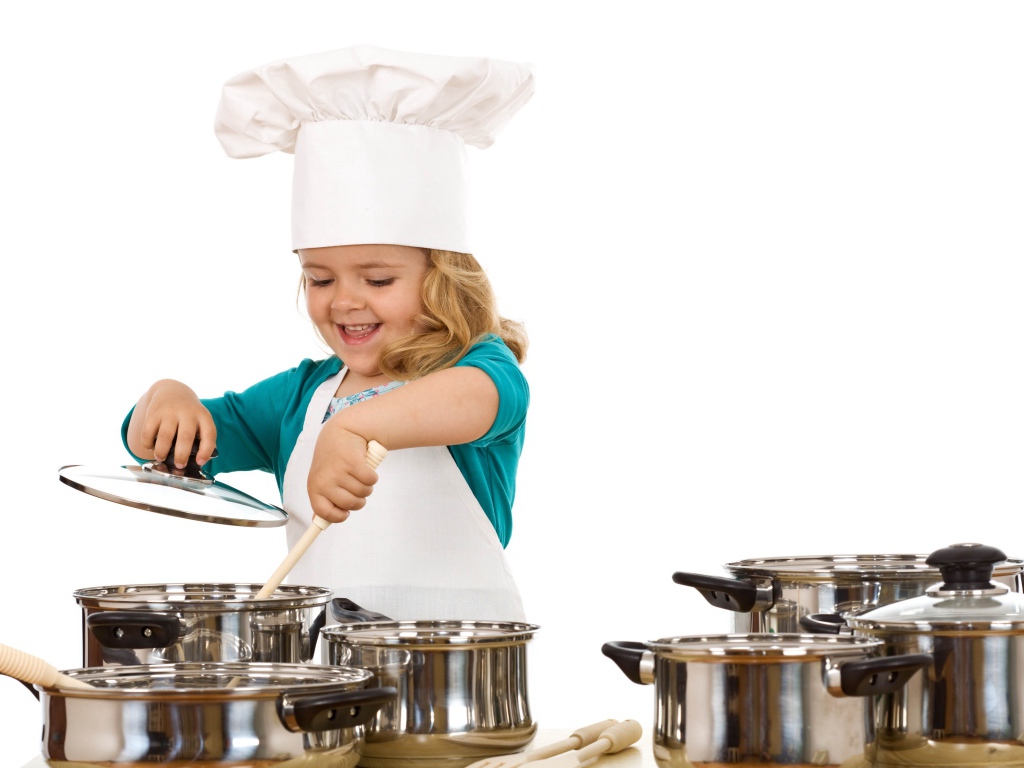 Маленькая девочка в костюме повара на кухне
