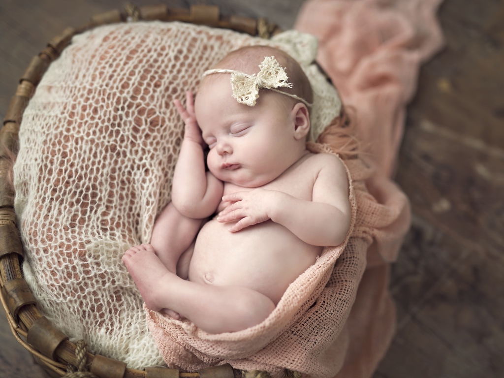 Новорожденная спящая девочка в корзине 
