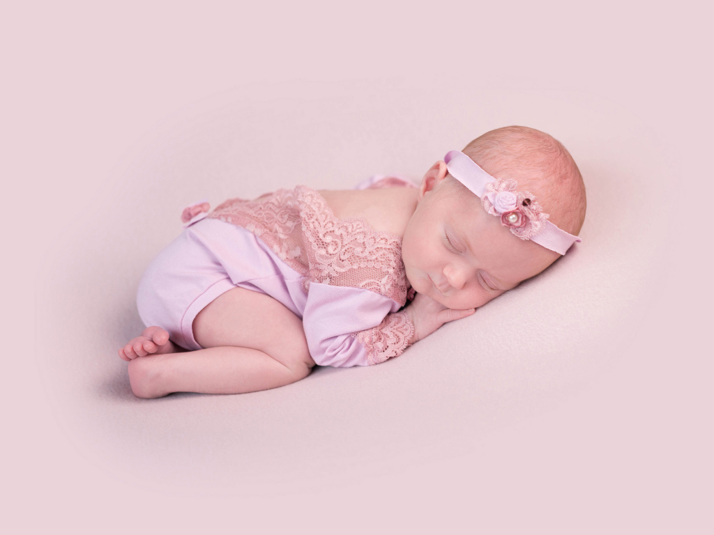 Спящий грудной ребенок на розовом фоне