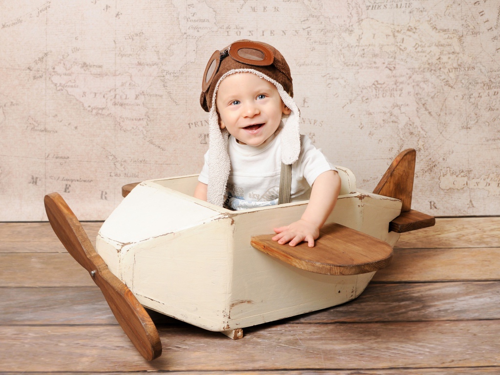 Улыбающийся маленький мальчик в игрушечном самолете