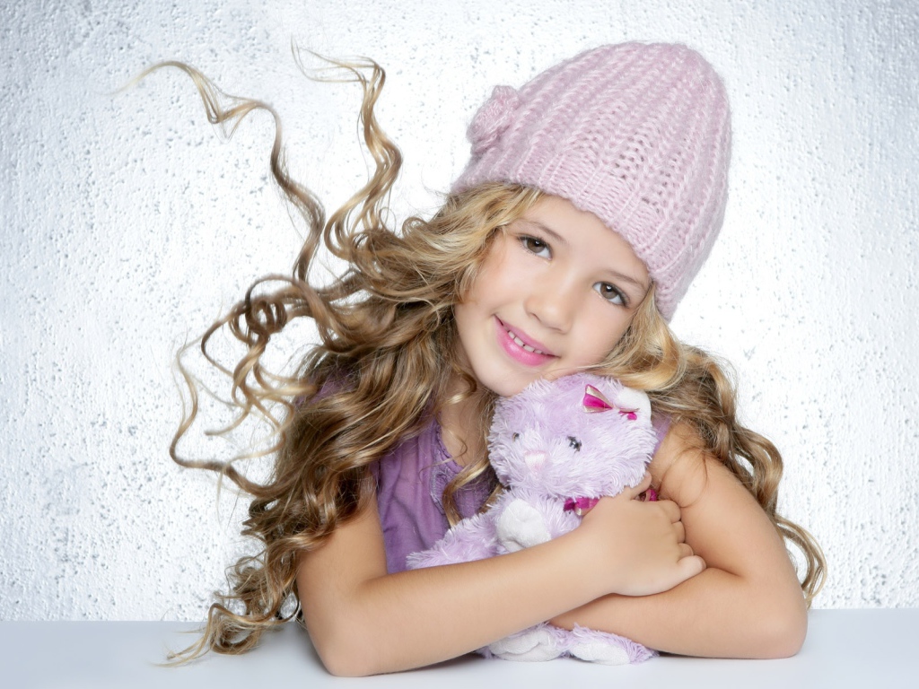 Милая светловолосая девочка с игрушкой