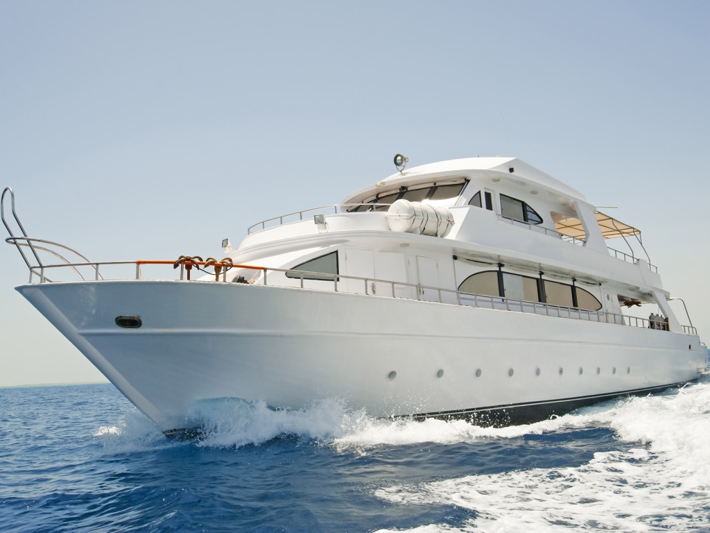 Красивая белая яхта в море на фоне голубого неба 