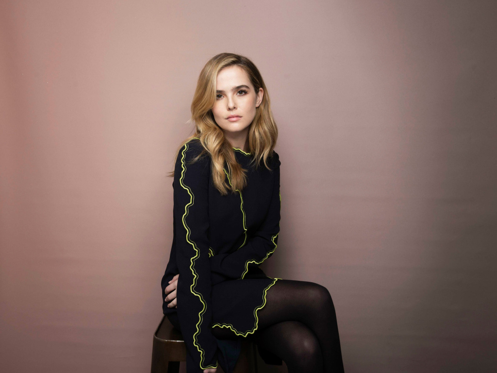 Актриса Зои Дойч в красивом платье сидит на стуле 