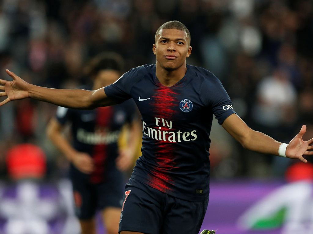 Французский футболист Килиан Мбаппе бежит по полю