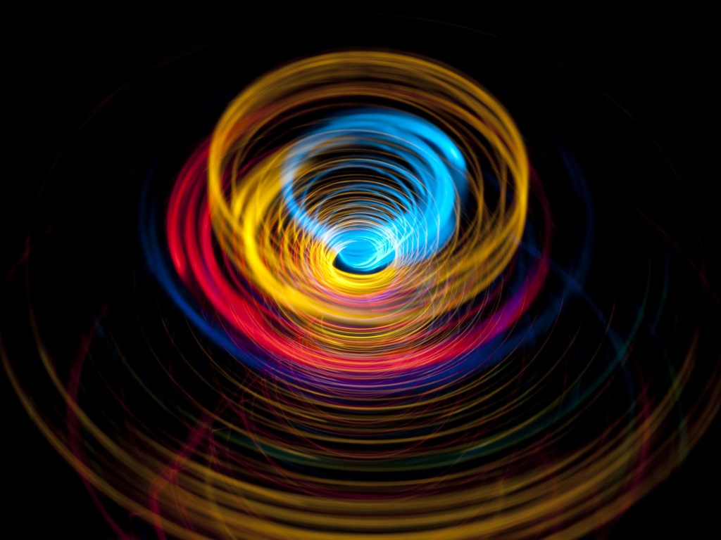 Разноцветные круги в воронке на черном фоне