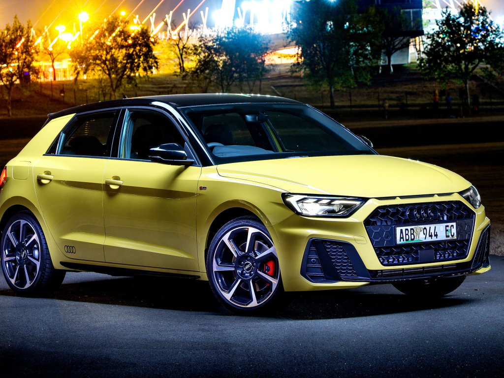 Желтый автомобиль Audi A1 Sportback 40 TFSI S Line Edition One 2019 года на фоне ночного города