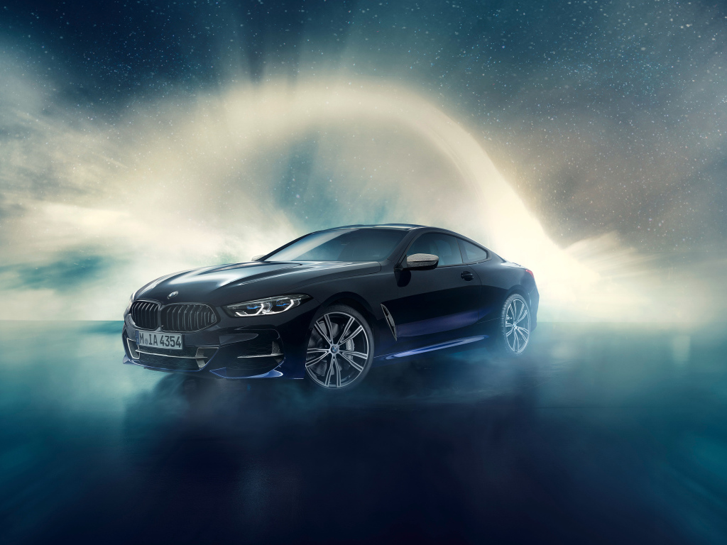 Черный автомобиль BMW M850i, 2019 года на фоне неба