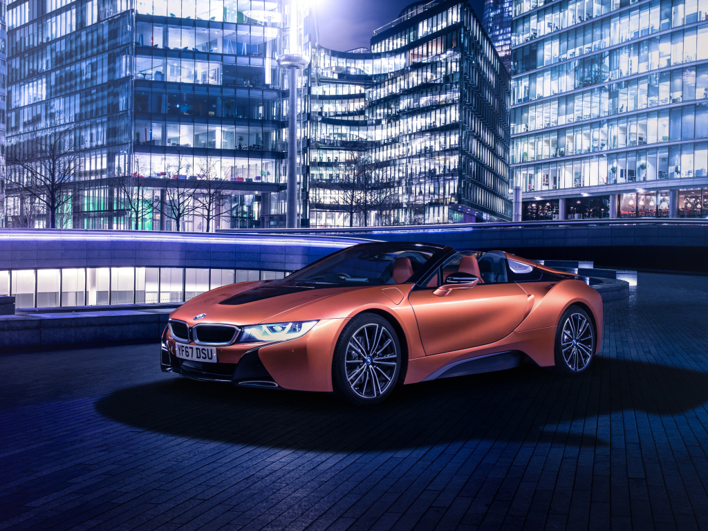 Дорогой оранжевый автомобиль BMW i8 на фоне здания